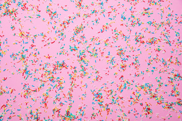 Birthday concept. Colorful sprinkles on pink background