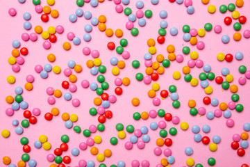 Birthday concept. Colorful round candies on pink background