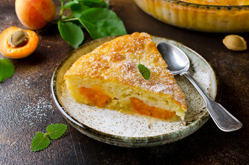 Sponge cake with apricots, dusted with icing sugar