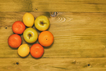 Fototapeta na wymiar Image of tangerine,lemon and apples on wooden table.Toned photo.