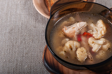 Chicken, potato and cauliflower soup on an old fabric background.