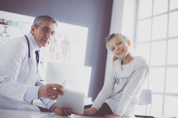 Portrait of a cute little girl and her doctor at hospital