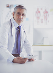 Portrait of a smiling doctor in his bright office