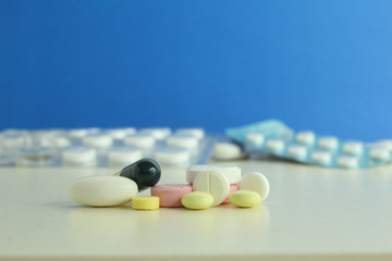 Capsule pills medical, white and pink, on a blue background.