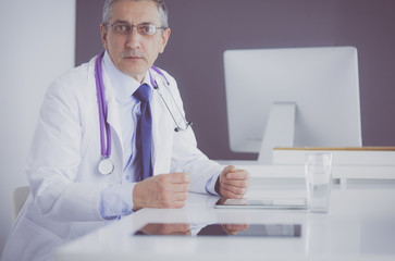 Portrait of senior doctor sitting in medical office