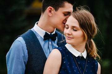 The face of young people. A young couple standing, hugging on the background nature. Close up. headshot, half length. Make-up and look at the camera.