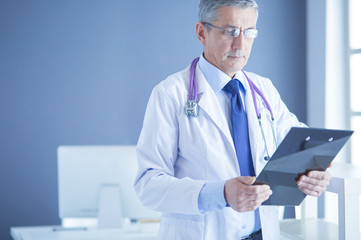 Male doctor writes notes on the clipboard in the hospital