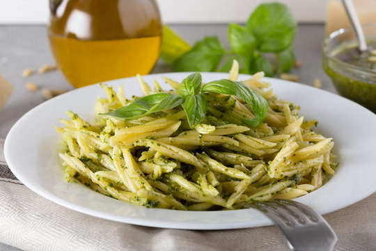 Traditional trofie pasta with pesto sauce on white plate