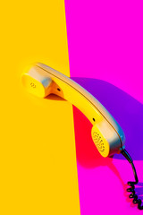 Retro vintage phone handset yellow pink red purple plastic orange disko background old style shadow...