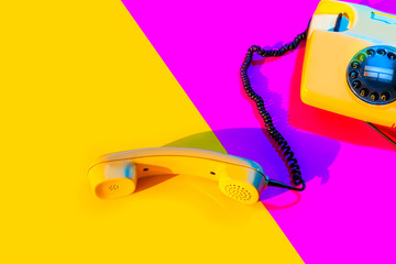 Retro vintage phone handset yellow pink red purple plastic orange disko background old style shadow...