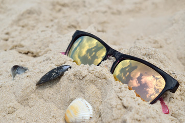 Reflection of the sky in sunglasses on the beach
