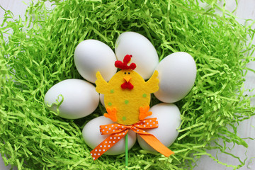 White eggs on green background. Easter. Easter background. Spring, Easter holiday. Eggs and Easter decoration decoration, chicken toy. Copy space.