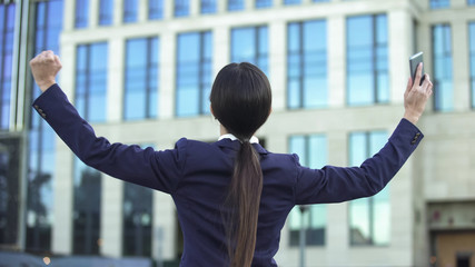 Extremely joyful lady making cheerful gesture, woman in business, back view