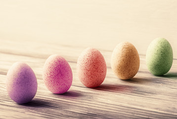Multicolored decorative Easter eggs on old wooden background