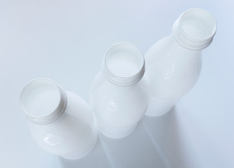 Empty white plastic milk bottles on White background