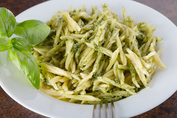 Traditional trofie pasta with pesto sauce on white plate