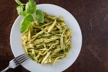 Traditional trofie pasta with pesto sauce on white plate