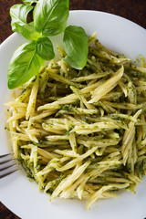 Traditional trofie pasta with pesto sauce on white plate