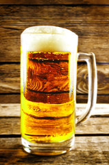 Glass of cold light beer with Easter decorations on a wood background for the Easter holidays