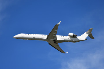 Fototapeta na wymiar White airplane flying, blue sky in background