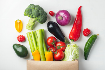Paper bag with vegetables on white background.