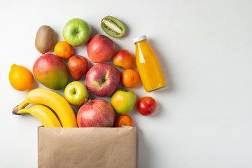 Paper bag of different health fruits on a table.