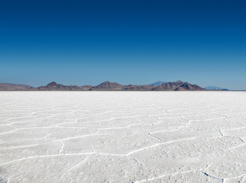 Panoramic view of the stark white Bonneville Salt Flats with mountains in the distance
