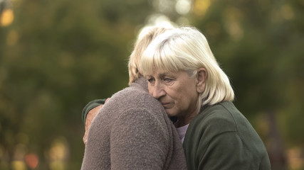 Depressed mature women hugging to support each other, family problems, care