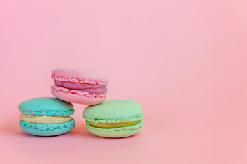 Sweet almond colorful unicorn blue green pink macaron or macaroon dessert cake isolated on trendy pink pastel background. French sweet cookie. Minimal food bakery concept. Copy space