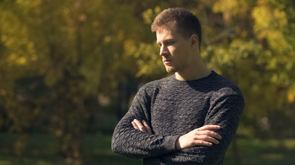 Worried man feeling insecurities in autumn park, life difficulties, problem