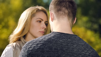Fototapeta premium Upset woman looking at man, apologizing after quarrel, misunderstanding problem