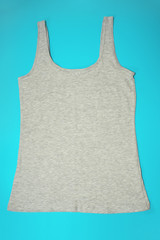 Gray sleeveless female casual tank top on blue background. Sport, fitness aparrel. Basic look.