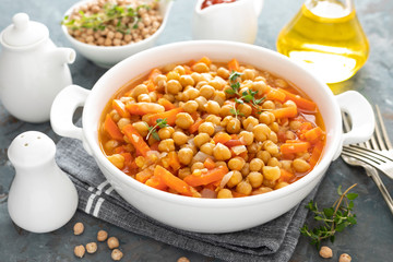 Chana Masala, spicy chickpea curry with carrot and onion in tomato sauce. Vegetarian dish for lunch. Indian cuisine