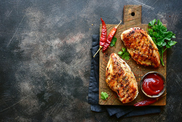 Grilled spicy chicken breast with ketchup.Top view with copy space. - obrazy, fototapety, plakaty