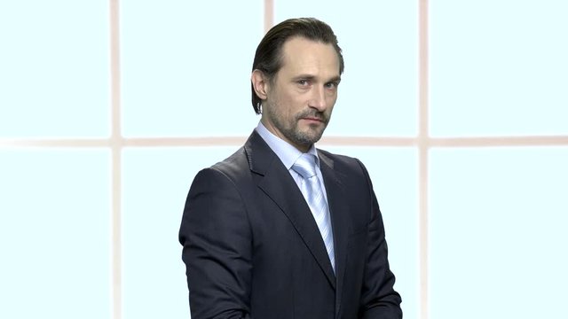 Portrait of mature businessman with distrustful look. Confident bearded man in formal wear expressing distrust emotion. Checkered window background.