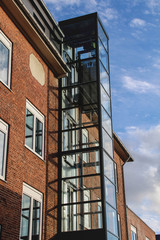 Fototapeta na wymiar Modernisierung - Gläserner Lift an der Außenfassade