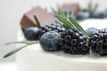 Delicious cake with berries and rosemary. Close-up view. Cake with blueberry and blackberry....