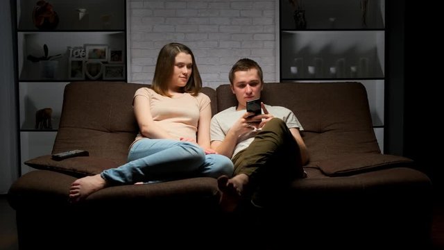 young couple is sitting on the sofa in the living room.