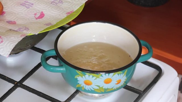A woman is cooking American donuts. Bake them in sunflower oil..