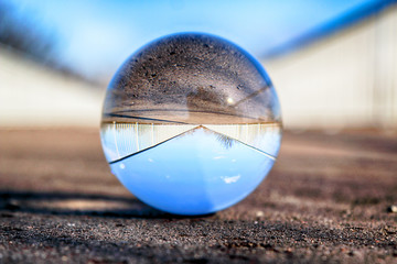 Long bridge in Wroclaw, Poland. View through a glass, crystal ball (lensball) for refraction...
