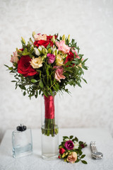 Wedding bouquet of red roses and white freesia flowers on wooden table. The bride's bouquet.