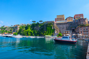 Obraz premium Seascape beautiful famous coastline. Yachts, boats and boats in the harbor. Seaside panoramic view of Sorrento, Naples, Campania, Italy.