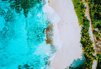 Aerial photo of amazing paradise tropical beach Anse Bazarca at Mahe island, Seychelles. White sand, turquoise water lagoon, palm trees and teal granite rocks