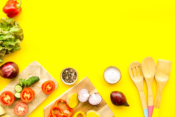 Vegan food cooking with raw vegetables on yellow background top view mock up