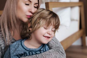 Mother is kissing his son. Mom and son. Happy mother's day. Mother hugging her child at home