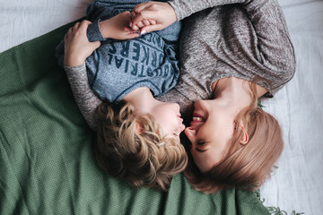 Beautiful woman and her cute little son are touching their noses and smiling