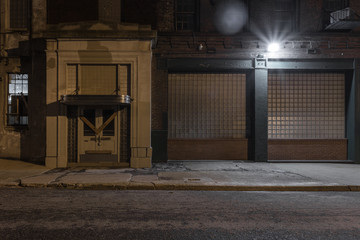 Boarded up entrance to an abandoned factory with classic architectural entrance at night