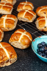 Freshly baked hotcross buns on a granite work surface