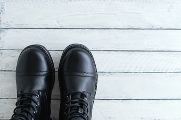 Black leather shoes with laces on a white wooden background. View from above. Close-up.