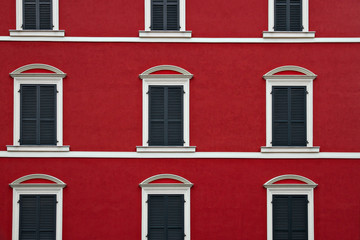 Typical building facade red and white color with windows in La Spezia, Italy